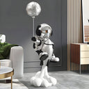 The Ascent silver astronaut sculpture with moon balloon