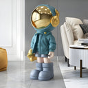 The Listener blue astronaut sculpture with gold headphones